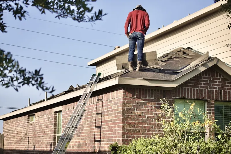 Professional roofer working on a residential roof in Center Pointe